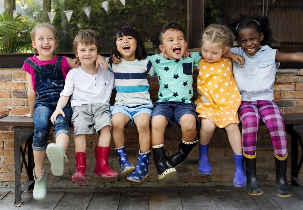 image of kids at school smiling together with their arms over each others shoulders