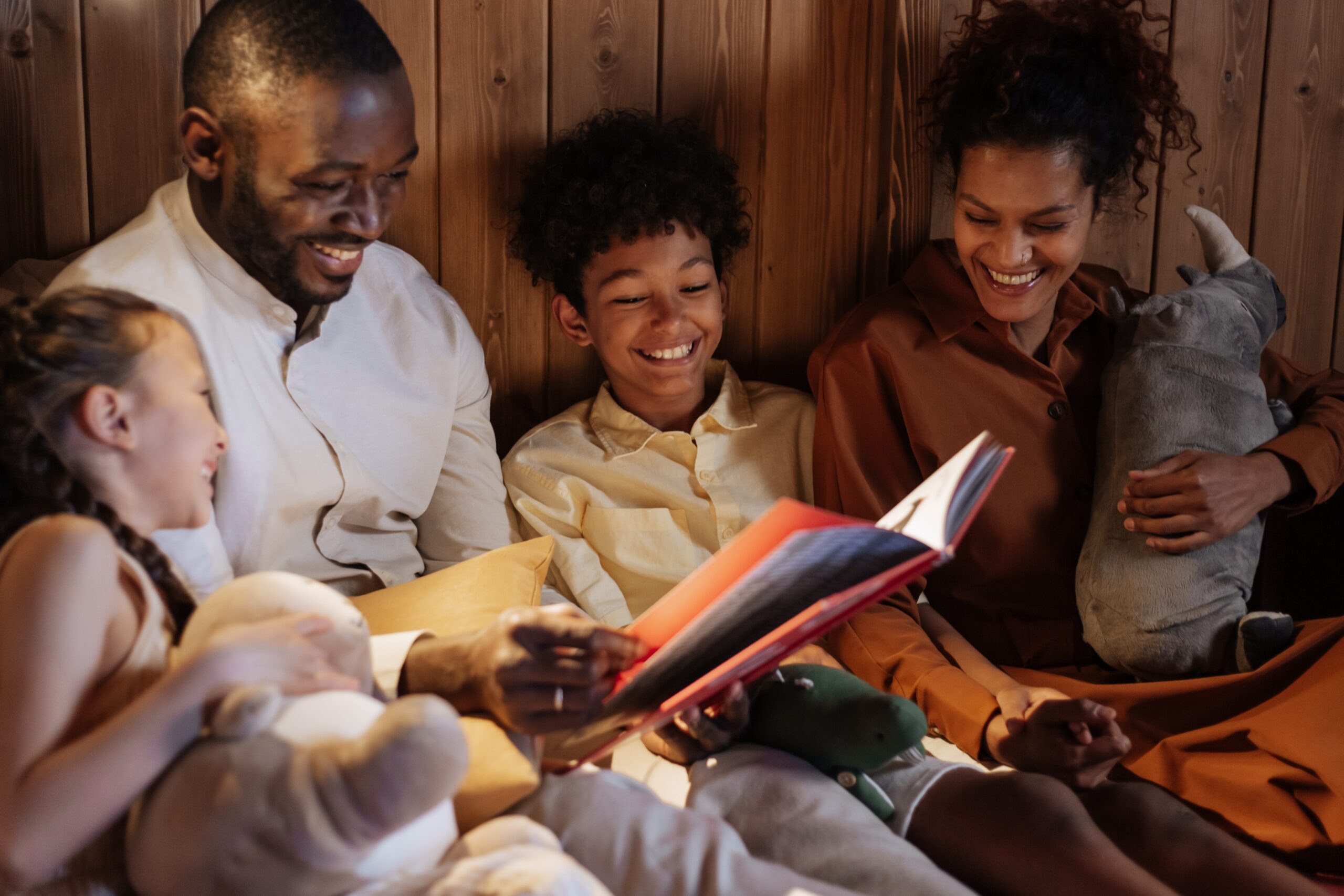 Diverse family reading together at home, promoting literacy and family bonding.